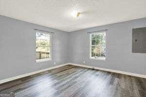 empty room featuring electric panel and dark hardwood / wood-style floors