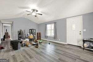 living room featuring ceiling fan, hardwood / wood-style flooring, and lofted ceiling