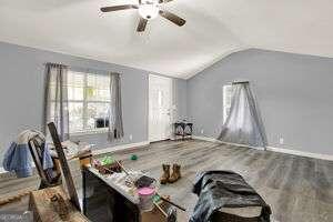 interior space with ceiling fan, lofted ceiling, and hardwood / wood-style floors