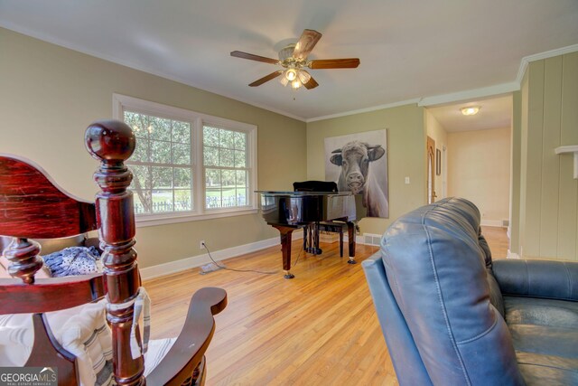 living room with crown molding, ceiling fan, and light hardwood / wood-style flooring