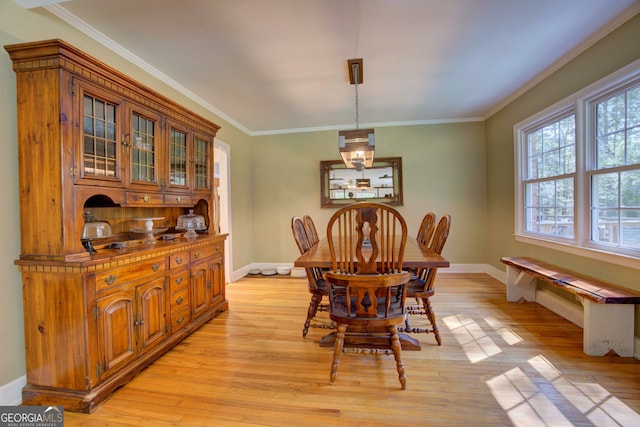 dining area with crown molding and light hardwood / wood-style floors