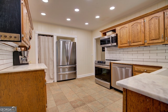 kitchen featuring stainless steel appliances, light tile patterned floors, tasteful backsplash, and crown molding