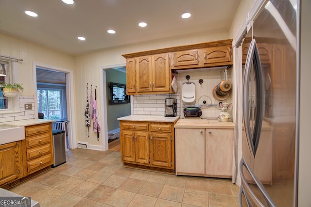 kitchen featuring stainless steel refrigerator, baseboard heating, and backsplash