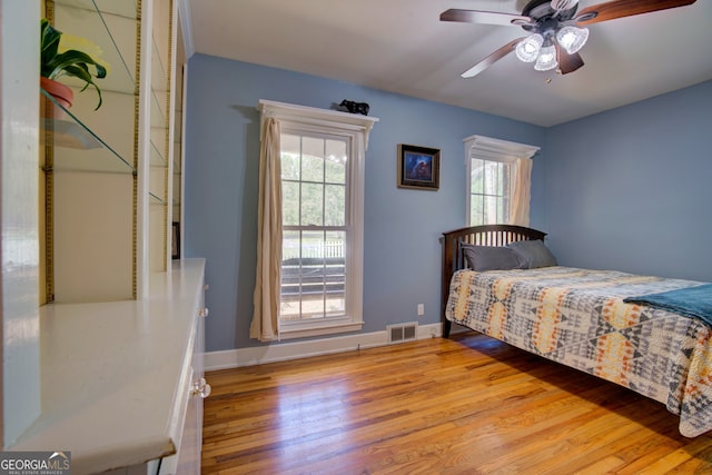 bedroom with multiple windows, ceiling fan, and light hardwood / wood-style flooring