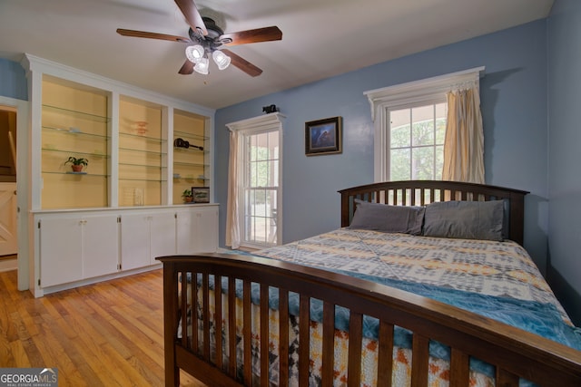 bedroom with ceiling fan, light hardwood / wood-style flooring, and multiple windows