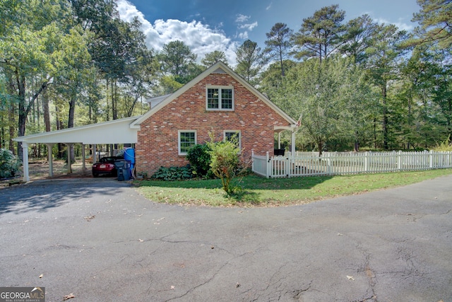 view of side of property featuring a lawn and a carport