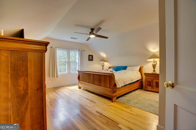 bedroom featuring wood-type flooring, vaulted ceiling, and ceiling fan