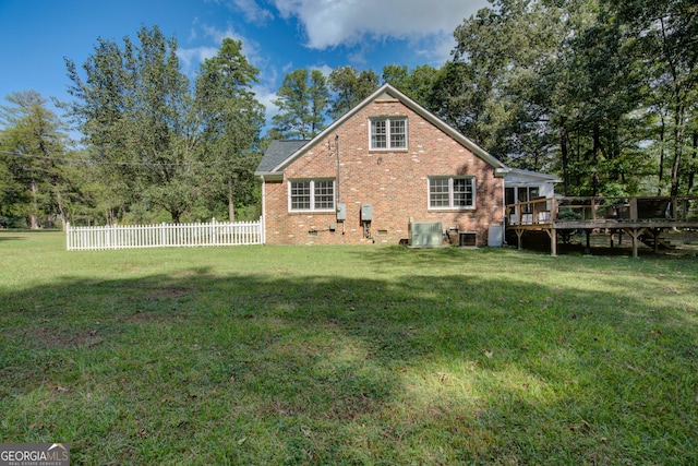 rear view of house with a lawn and a wooden deck