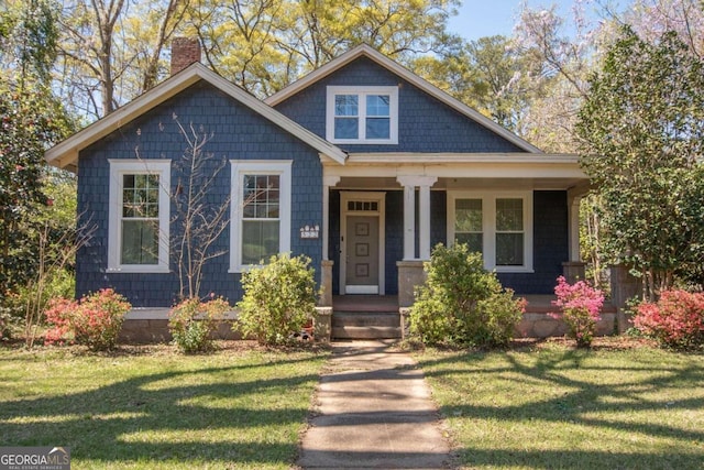 view of front of home with a porch and a front lawn