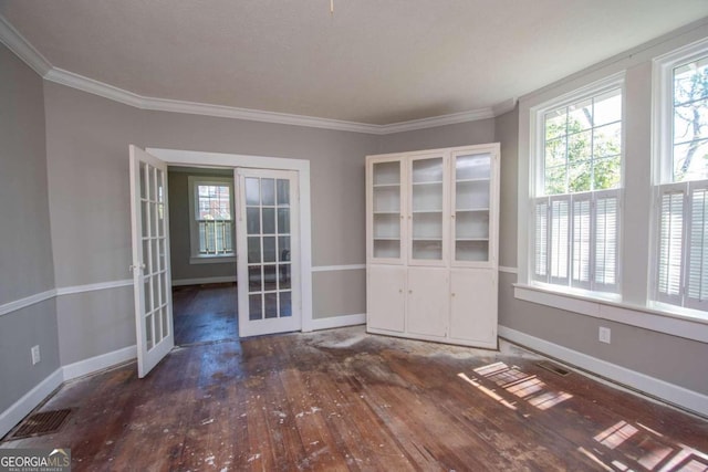 unfurnished room featuring a textured ceiling, crown molding, dark wood-type flooring, and french doors