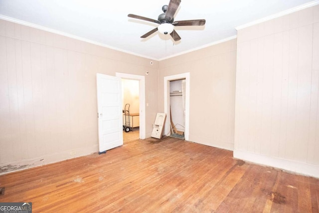 unfurnished bedroom with wood-type flooring, ornamental molding, ceiling fan, and a closet