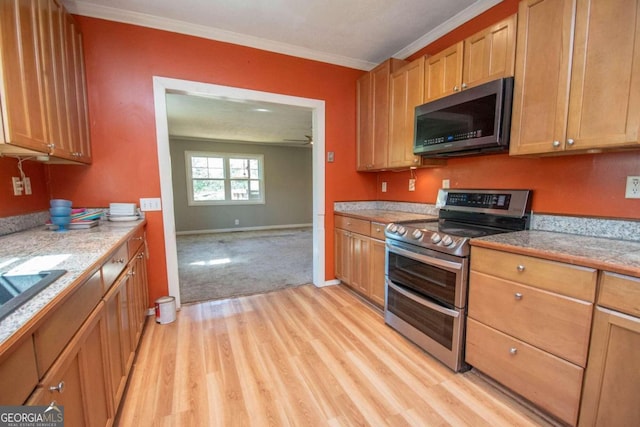 kitchen featuring appliances with stainless steel finishes, crown molding, and light wood-type flooring