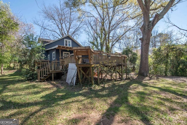 back of house featuring a deck and a yard