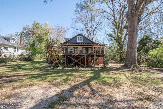 rear view of property with a lawn and a wooden deck