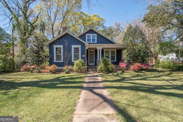 view of front facade featuring a front yard and covered porch