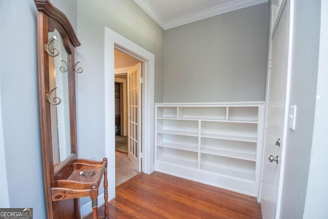 corridor with ornamental molding and hardwood / wood-style floors