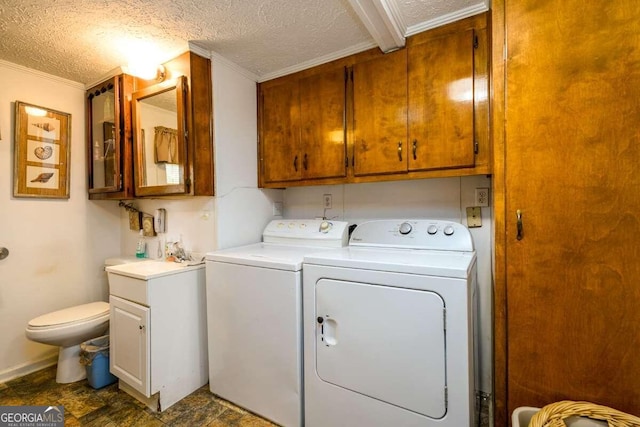 washroom featuring washer and clothes dryer, a textured ceiling, and ornamental molding