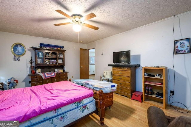 bedroom with crown molding, ceiling fan, hardwood / wood-style flooring, and a textured ceiling