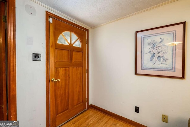 entryway featuring a textured ceiling, light hardwood / wood-style flooring, and crown molding