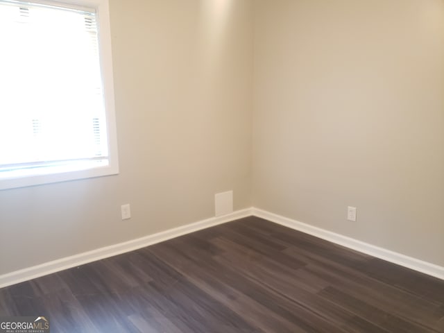 unfurnished room with dark hardwood / wood-style flooring