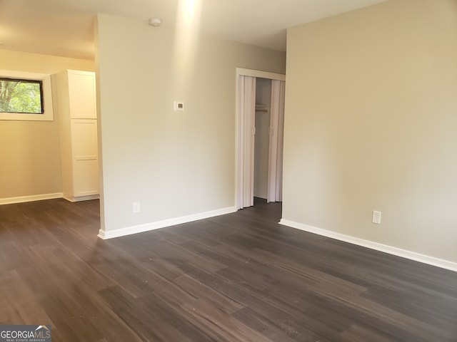 unfurnished room with dark hardwood / wood-style floors