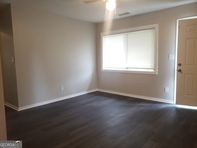 spare room featuring ceiling fan and dark wood-type flooring