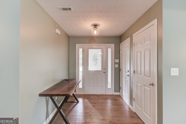 entryway featuring a textured ceiling and hardwood / wood-style flooring