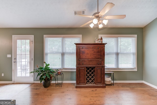 interior space with light hardwood / wood-style flooring, ceiling fan, and a textured ceiling