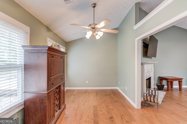 dining area with light hardwood / wood-style flooring, vaulted ceiling, ceiling fan, and plenty of natural light