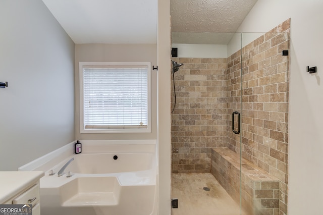 bathroom featuring a textured ceiling, vanity, and separate shower and tub