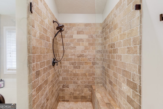 bathroom featuring a textured ceiling and tiled shower