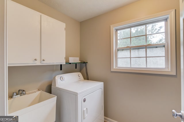 laundry room featuring a textured ceiling, sink, washer / dryer, and cabinets