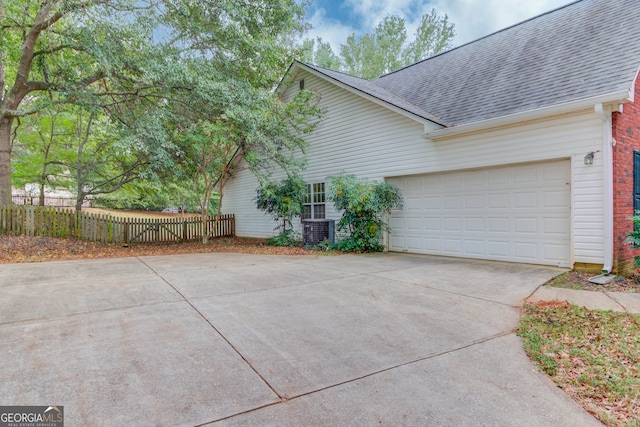 view of property exterior featuring central air condition unit and a garage