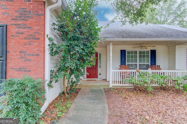 view of exterior entry with ceiling fan and a porch