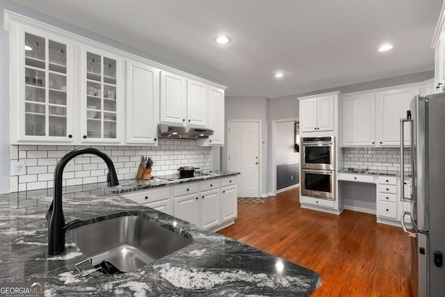 kitchen with white cabinetry, sink, stainless steel appliances, and tasteful backsplash