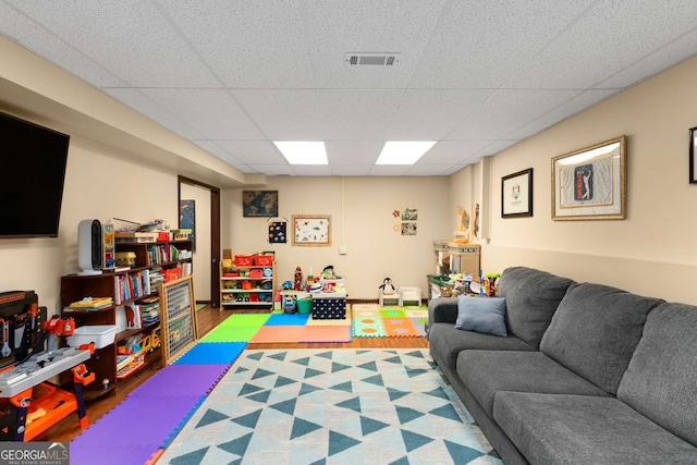 recreation room with wood-type flooring and a paneled ceiling