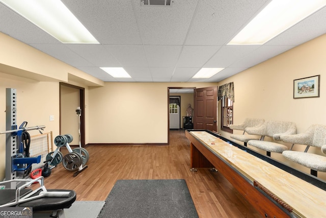 game room with wood-type flooring and a paneled ceiling