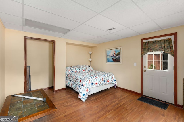 bedroom featuring a paneled ceiling and hardwood / wood-style flooring