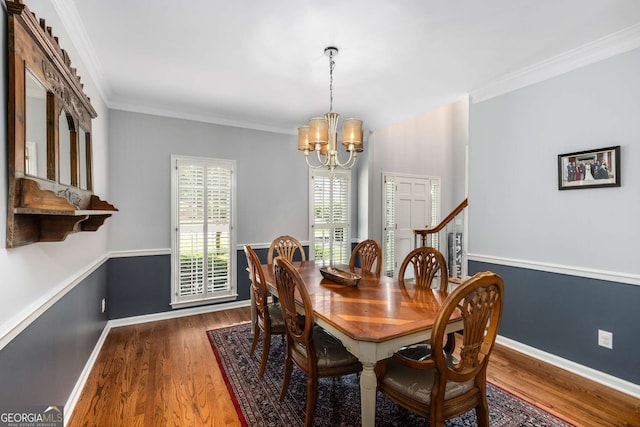 dining room with an inviting chandelier, crown molding, and dark wood-type flooring