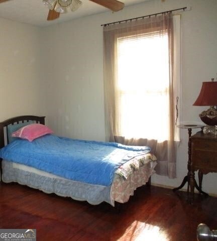 bedroom with ceiling fan and dark hardwood / wood-style flooring