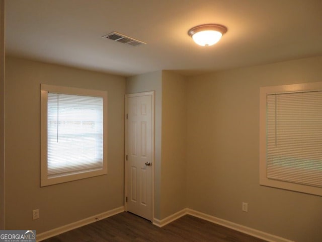 unfurnished room with dark hardwood / wood-style floors