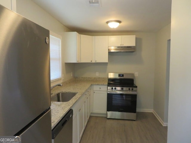 kitchen with light stone counters, dark wood-type flooring, sink, white cabinetry, and appliances with stainless steel finishes