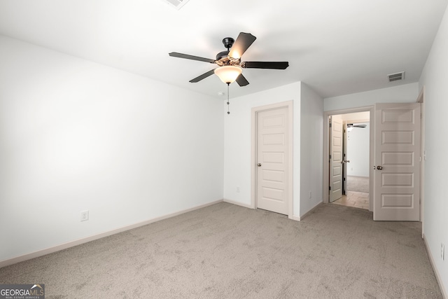 unfurnished bedroom featuring light carpet, ceiling fan, and a closet