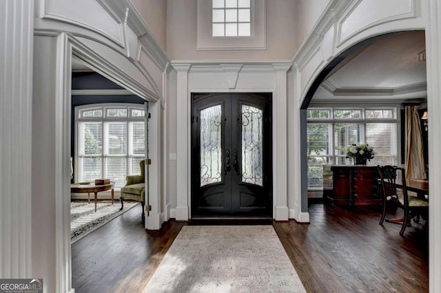 foyer with french doors, crown molding, dark hardwood / wood-style flooring, and a healthy amount of sunlight