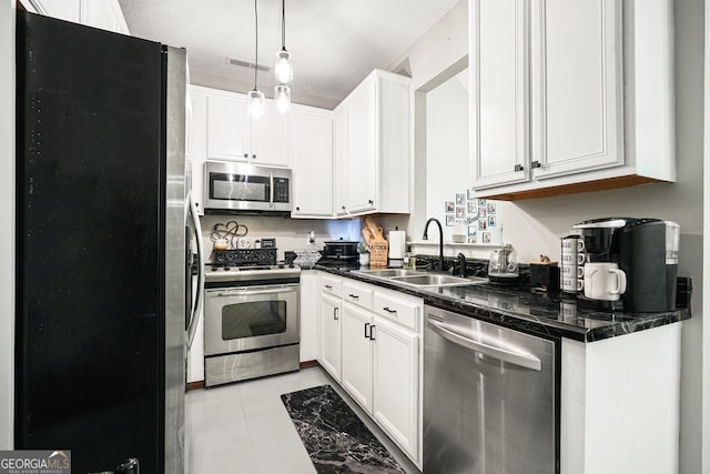 kitchen featuring sink, a textured ceiling, stainless steel appliances, pendant lighting, and white cabinets