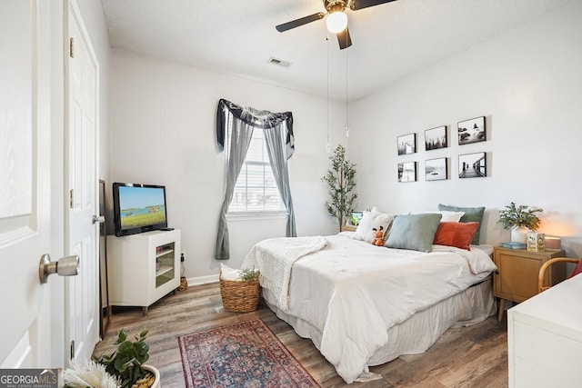 bedroom featuring a textured ceiling, hardwood / wood-style flooring, and ceiling fan