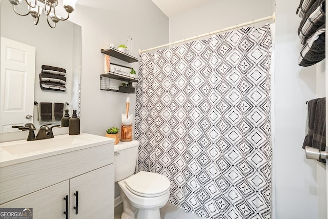 bathroom featuring an inviting chandelier, vanity, a textured ceiling, and toilet