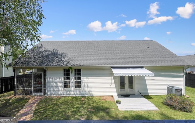 back of property with french doors, a yard, and central AC unit