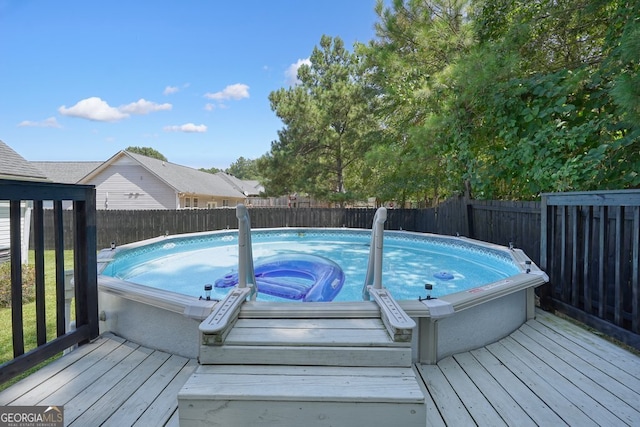 view of swimming pool with a wooden deck and a jacuzzi