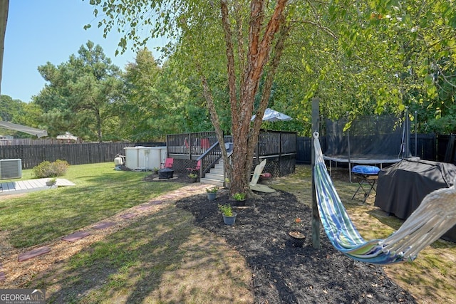 view of yard featuring a storage shed and a trampoline